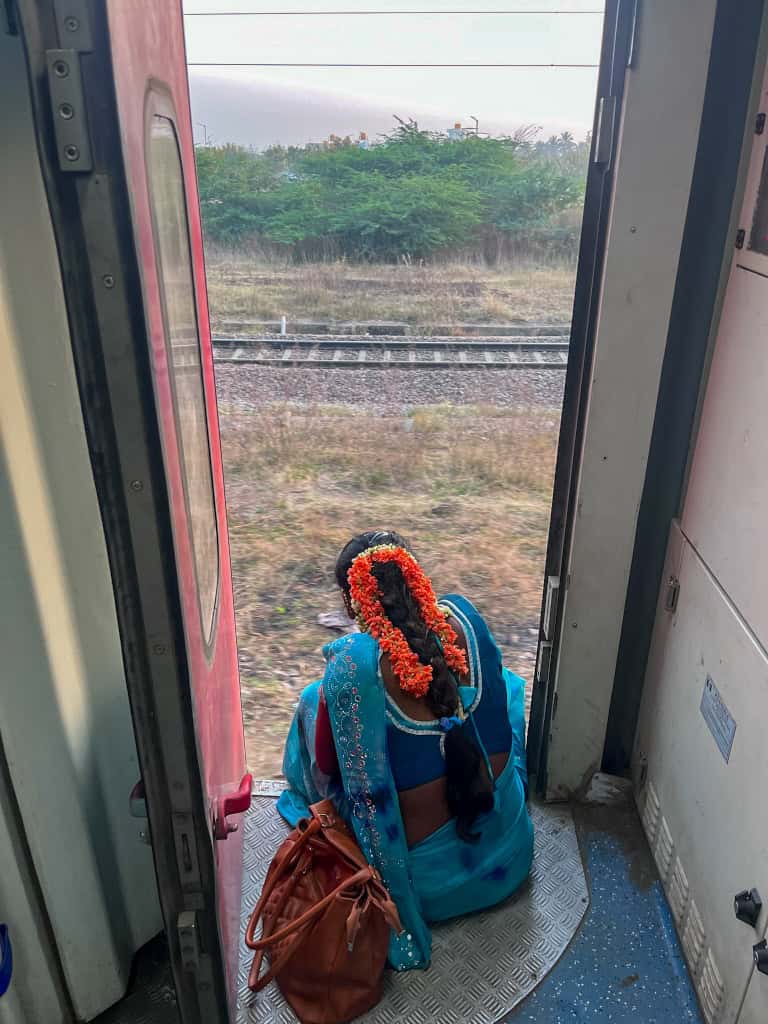 Woman sitting in Indian train door